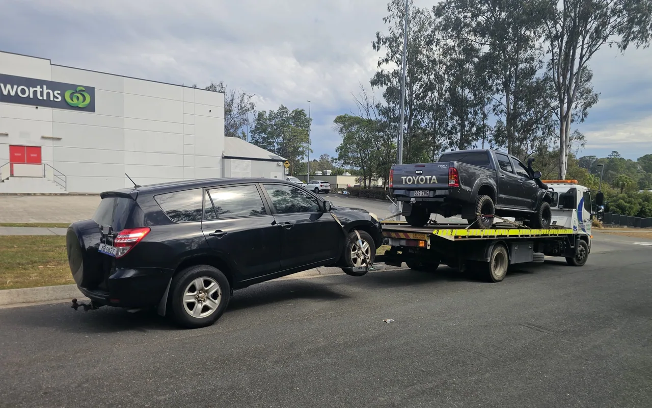 Two Toyota vehicles being prepared for transport on a tow truck