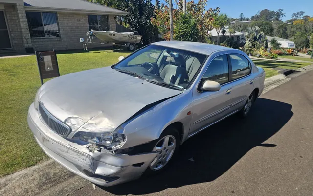 Damaged Nissan sedan from the AK Cash for Cars purchase collection